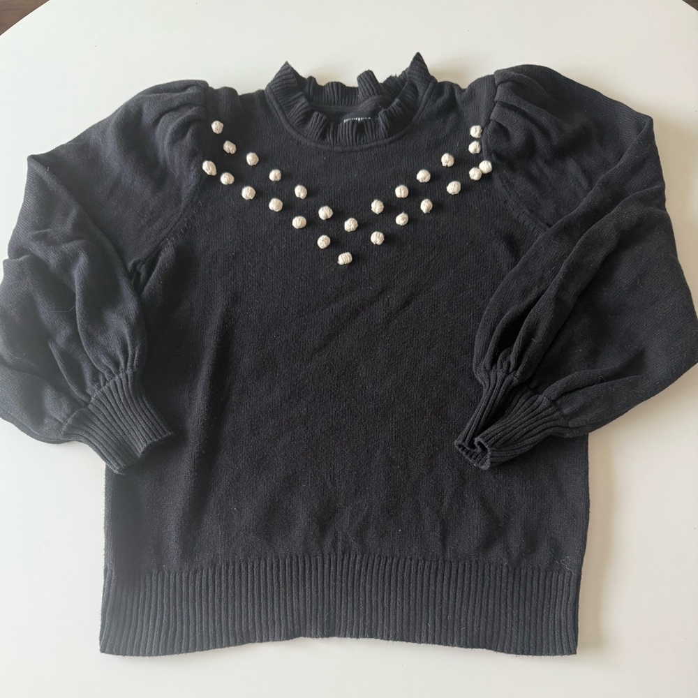 Black cotton sweater with cream pompoms